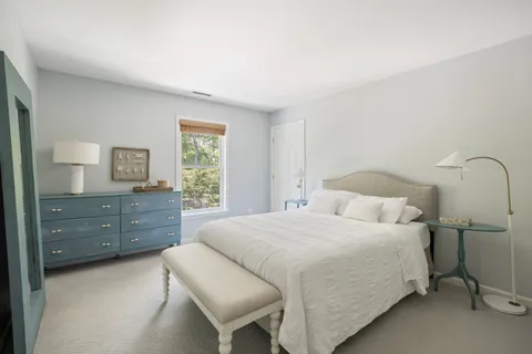 a large bedroom with a bed wooden floor and window