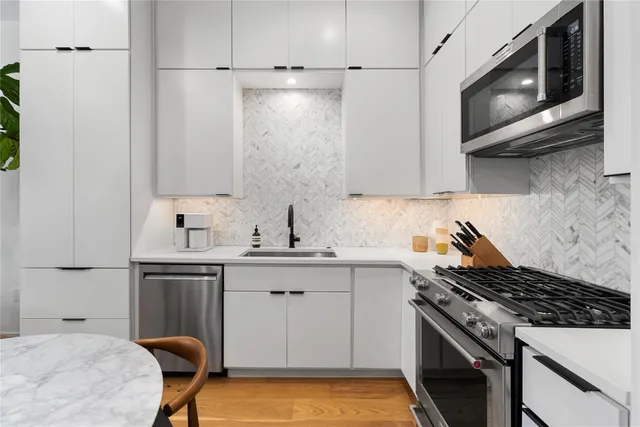 a kitchen with stainless steel appliances a stove a sink and a microwave