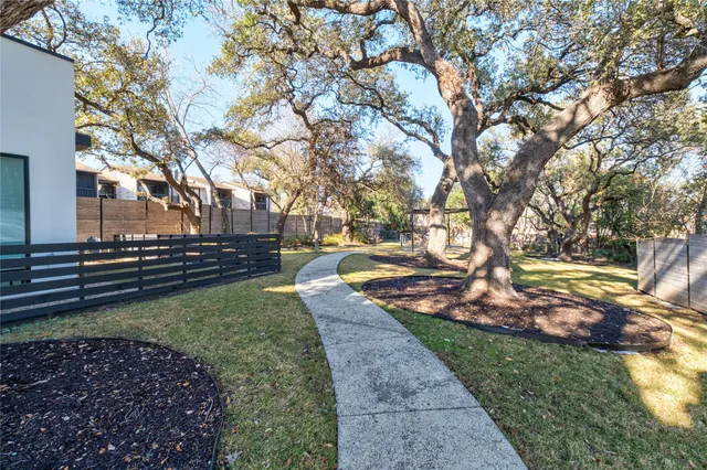 a view of a backyard with large trees