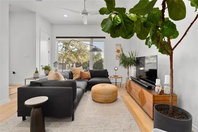 a living room with furniture a chandelier and a flat screen tv