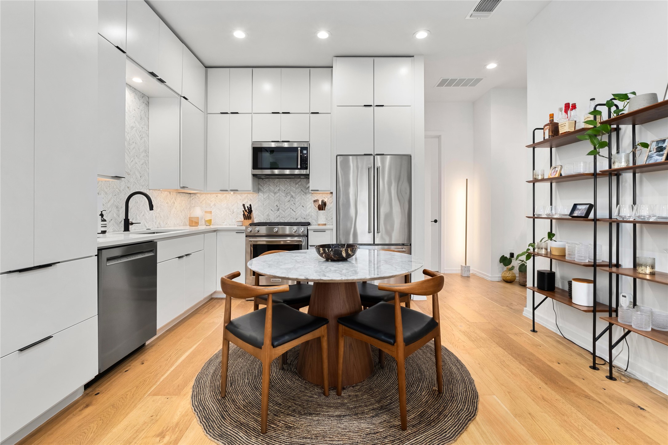 410 West Alpine Road, Unit 10 Austin, TX 78704 - Photo 8 of 31 a kitchen with stainless steel appliances a dining table chairs a refrigerator and cabinets