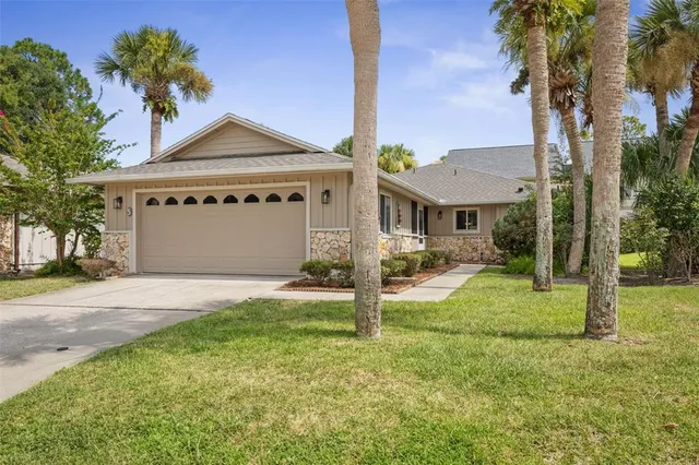 a view of a house with a yard and palm tree