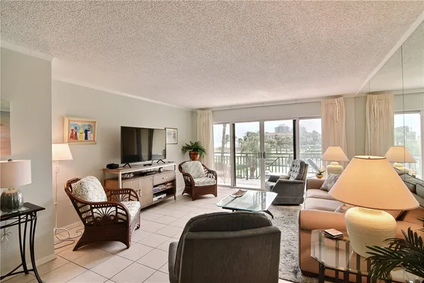 a living room with furniture floor to ceiling window and a flat screen tv