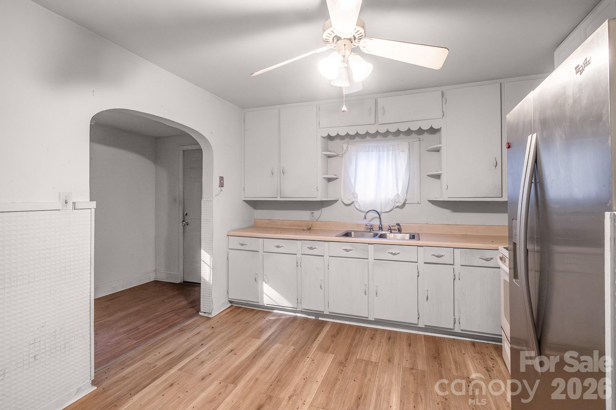 4430 West Tyvola Road Charlotte, NC 28208 - Photo 12 of 33 a kitchen with stainless steel appliances granite countertop a refrigerator a sink dishwasher a stove and white cabinets with wooden floor