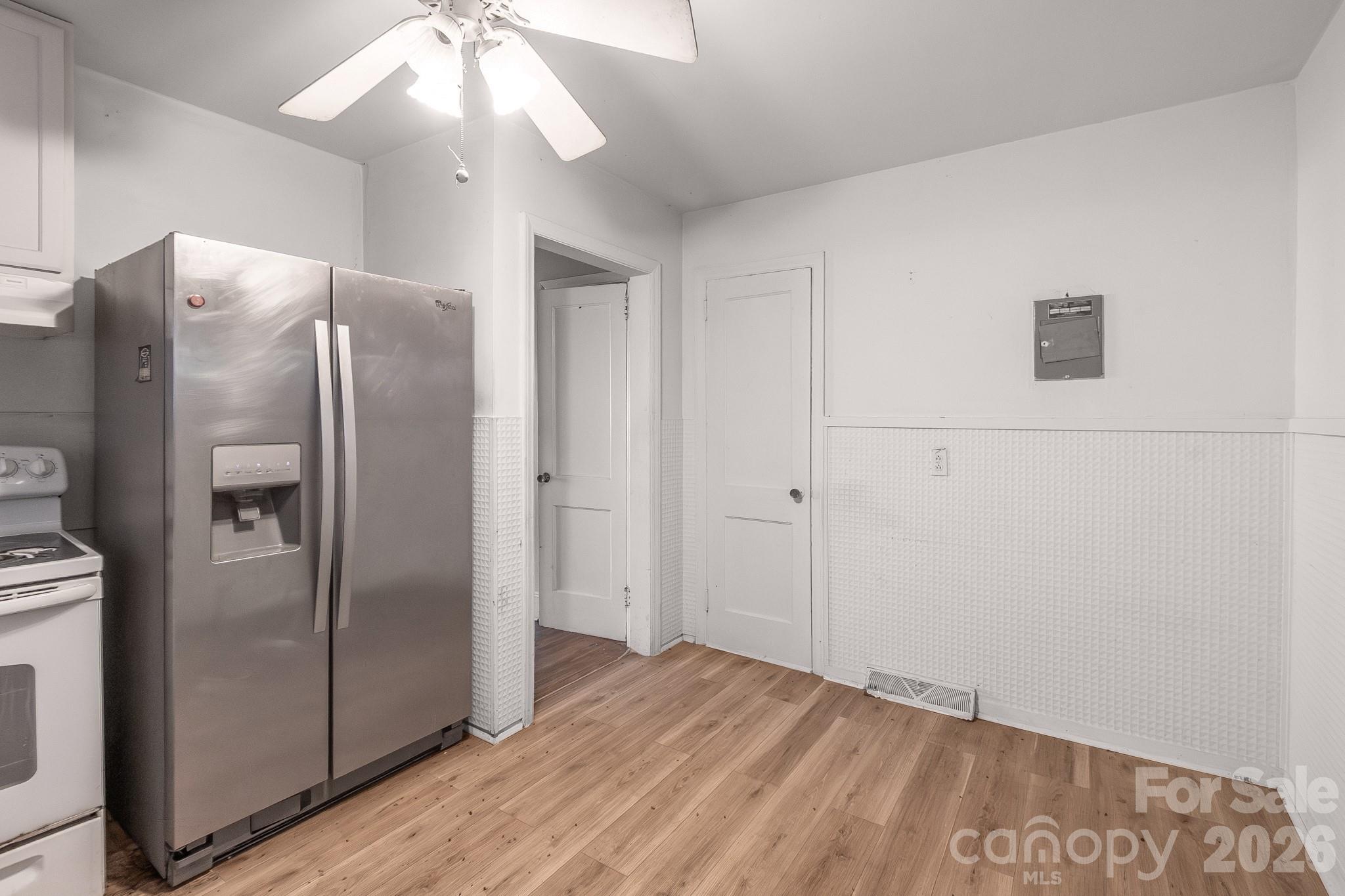 4430 West Tyvola Road Charlotte, NC 28208 - Photo 14 of 33 a view of a refrigerator in kitchen and an empty room with wooden floor