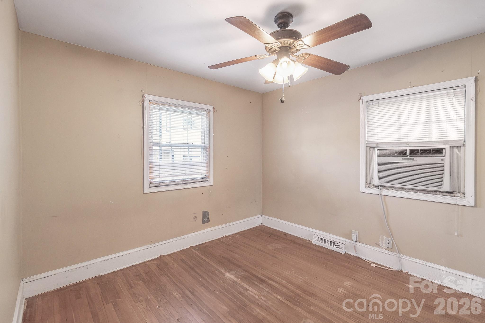 4430 West Tyvola Road Charlotte, NC 28208 - Photo 22 of 33 a view of an empty room with wooden floor and a window