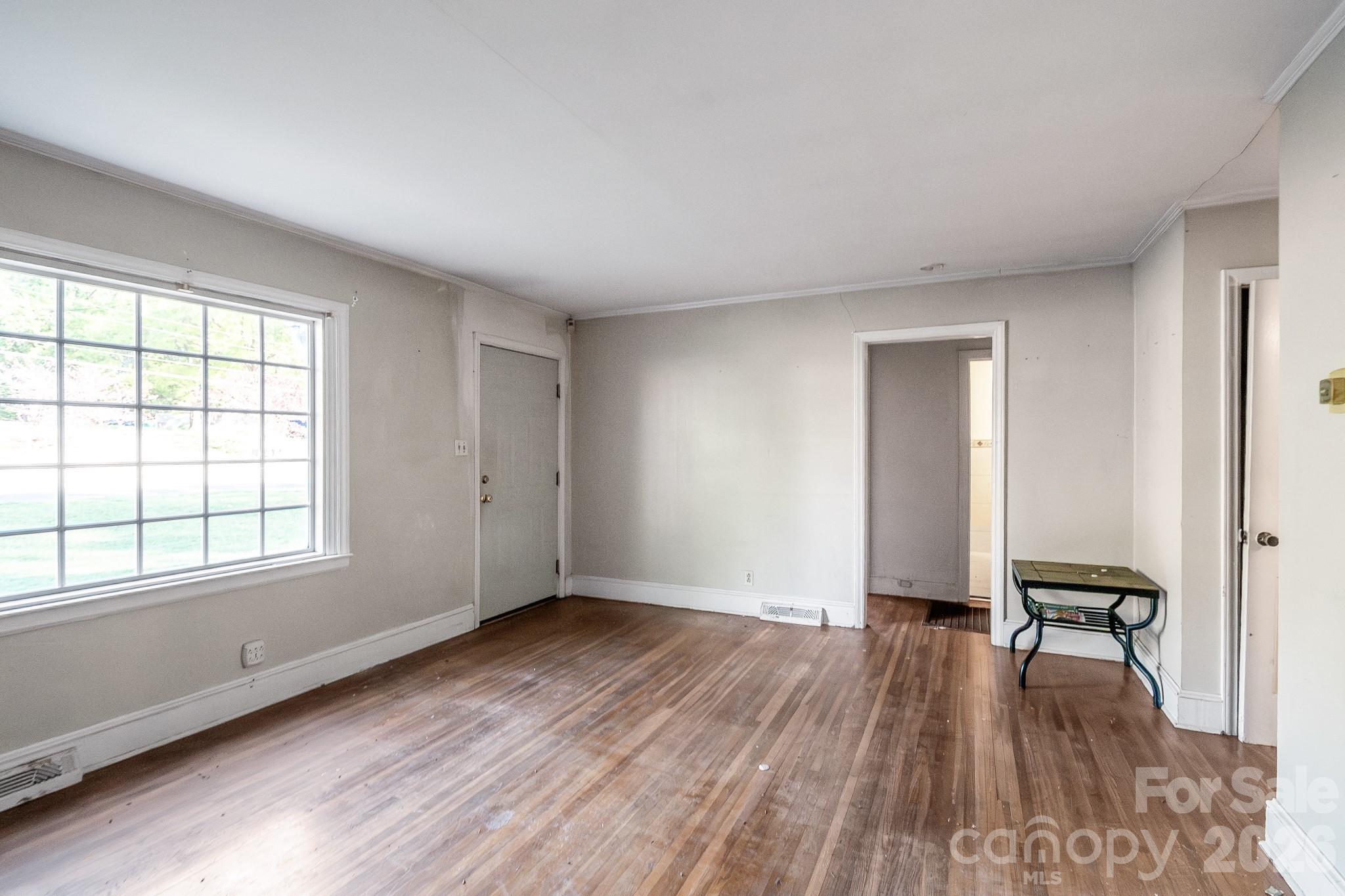 4430 West Tyvola Road Charlotte, NC 28208 - Photo 8 of 33 an empty room with wooden floor and a window