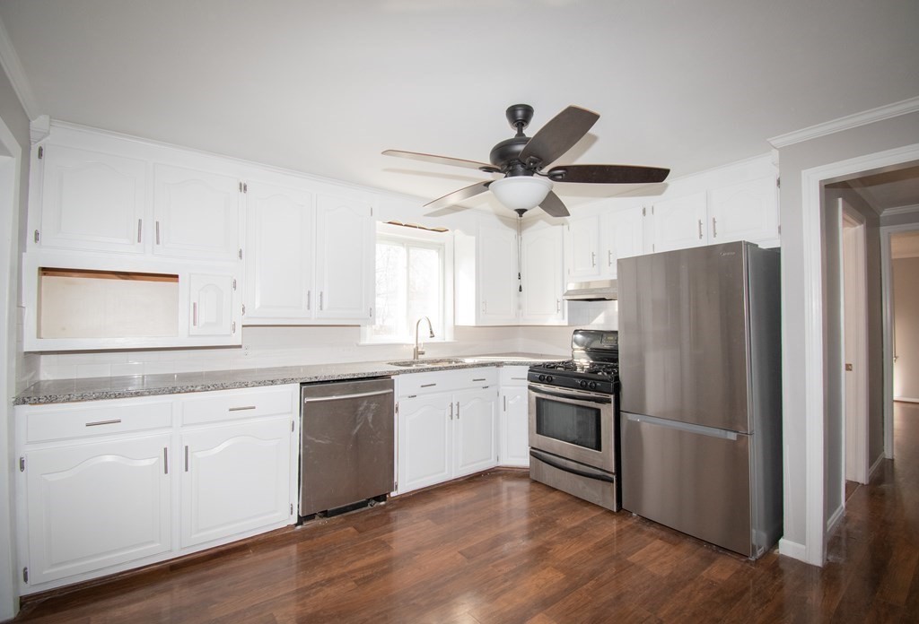 24 Lumae Street Springfield, MA 01119 - Photo 30 of 33 a kitchen with stainless steel appliances granite countertop a refrigerator a stove a sink and white cabinets with wooden floor next to windows