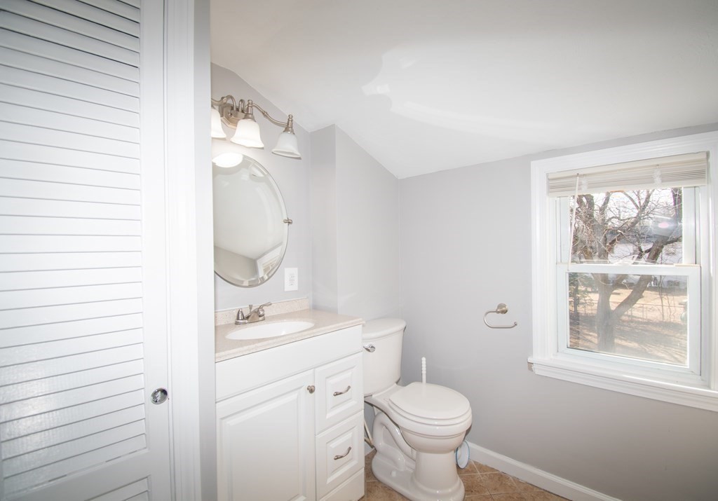 24 Lumae Street Springfield, MA 01119 - Photo 9 of 33 a bathroom with a toilet a sink a mirror and a window
