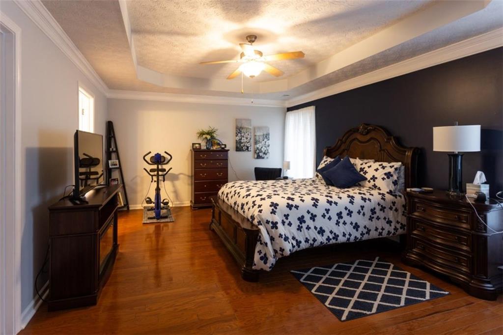 164 Laurel Lane Social Circle, GA 30025 - Photo 16 of 38 a bedroom with a large bed and a chandelier