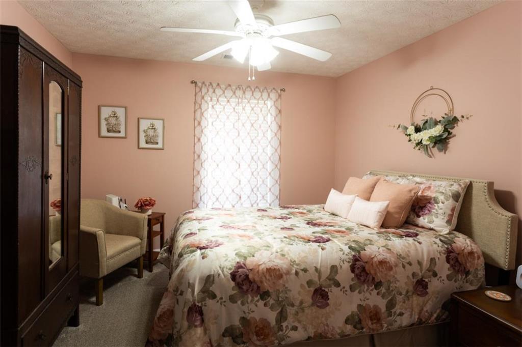 164 Laurel Lane Social Circle, GA 30025 - Photo 22 of 38 a bedroom with a bed and a chandelier