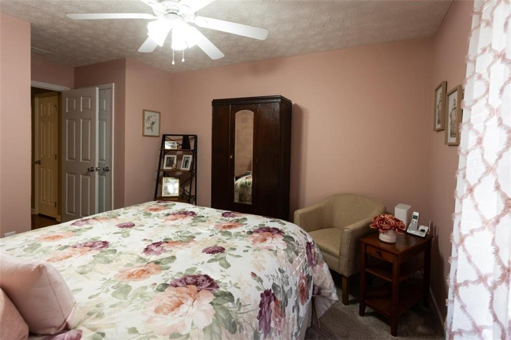 164 Laurel Lane Social Circle, GA 30025 - Photo 23 of 38 a bedroom with a bed and a chandelier