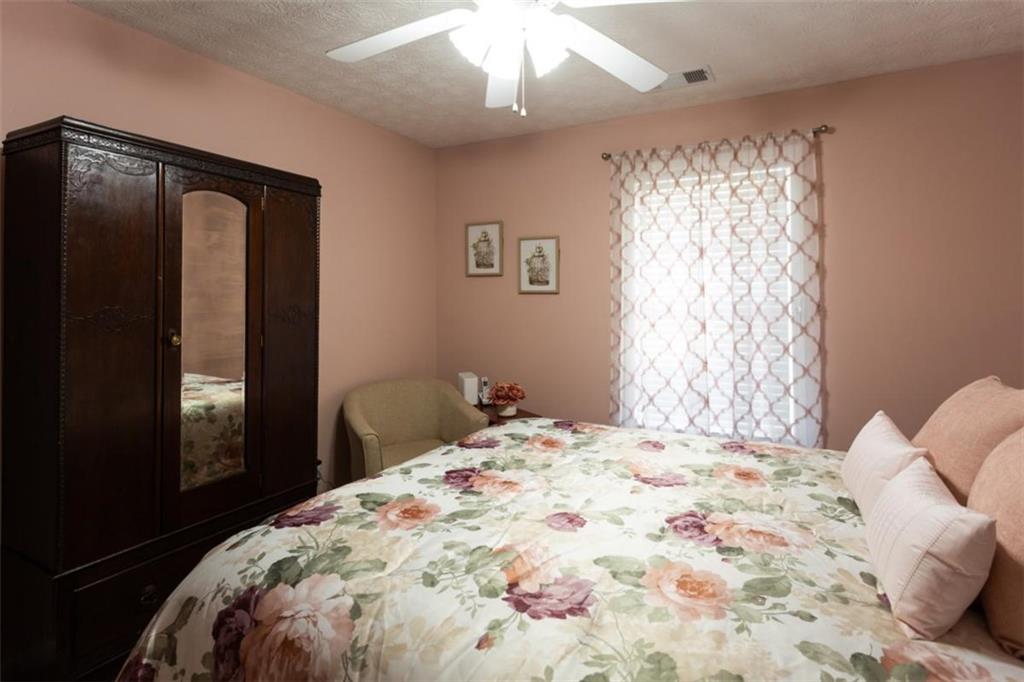 164 Laurel Lane Social Circle, GA 30025 - Photo 24 of 38 a bedroom with a large bed and a chandelier