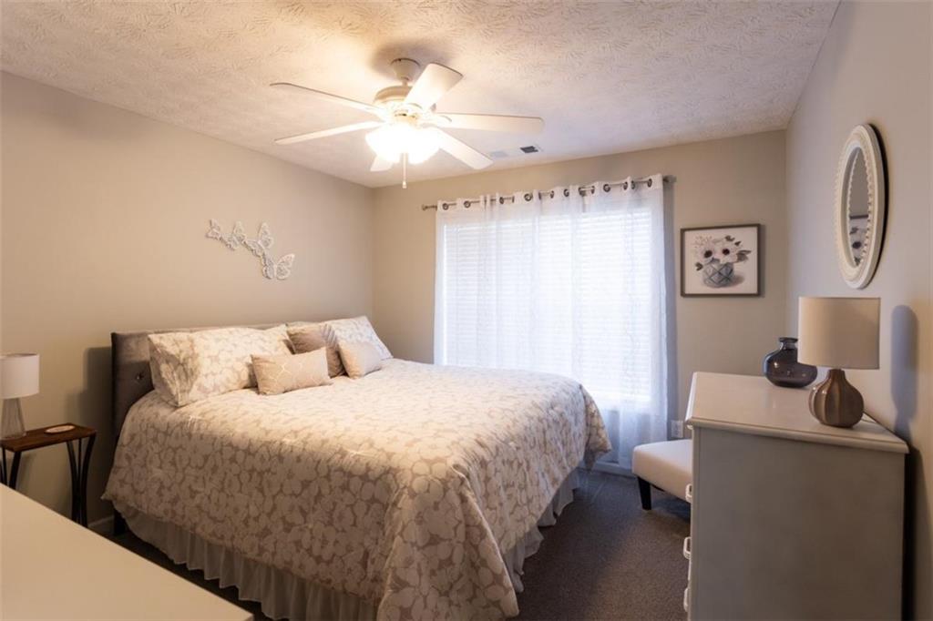 164 Laurel Lane Social Circle, GA 30025 - Photo 26 of 38 a bedroom with a bed and a chandelier