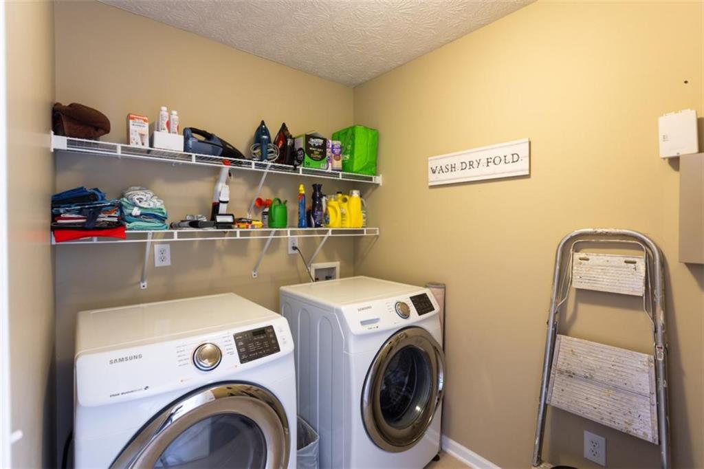 164 Laurel Lane Social Circle, GA 30025 - Photo 29 of 38 a view of washer and dryer with kitchen in the background