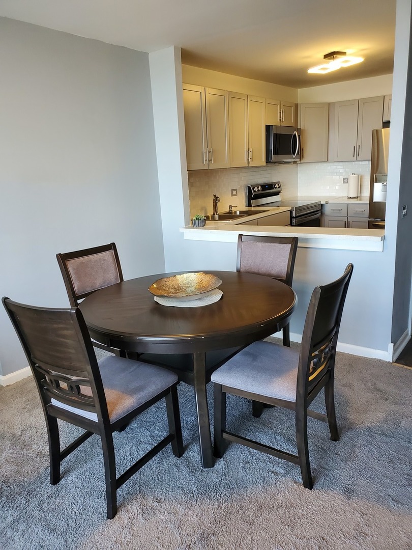 5415 North Sheridan Road, Unit 4809 Chicago, IL 60640 - Photo 8 of 12 a kitchen with a dining table chairs and a kitchen view