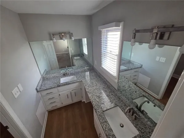 a bathroom with a granite countertop sink and a mirror