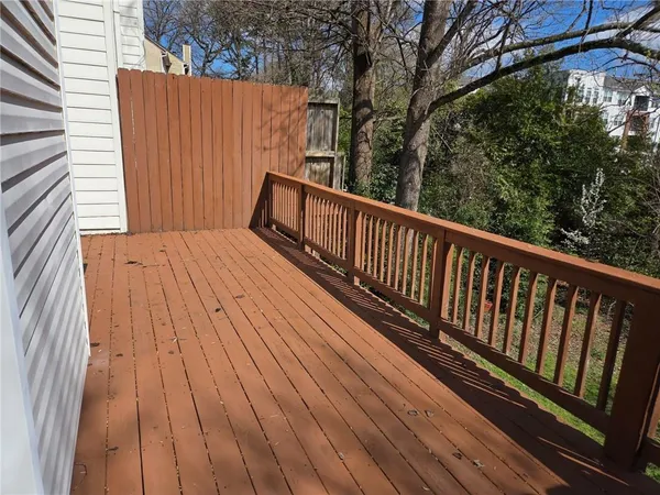 a view of balcony with wooden floor and fence