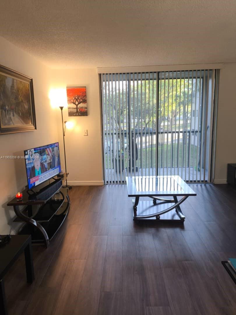 8650 Southwest 133rd Avenue Road, Unit 208 Miami, FL 33183 - Photo 5 of 10 a living room with hardwood floor and a window