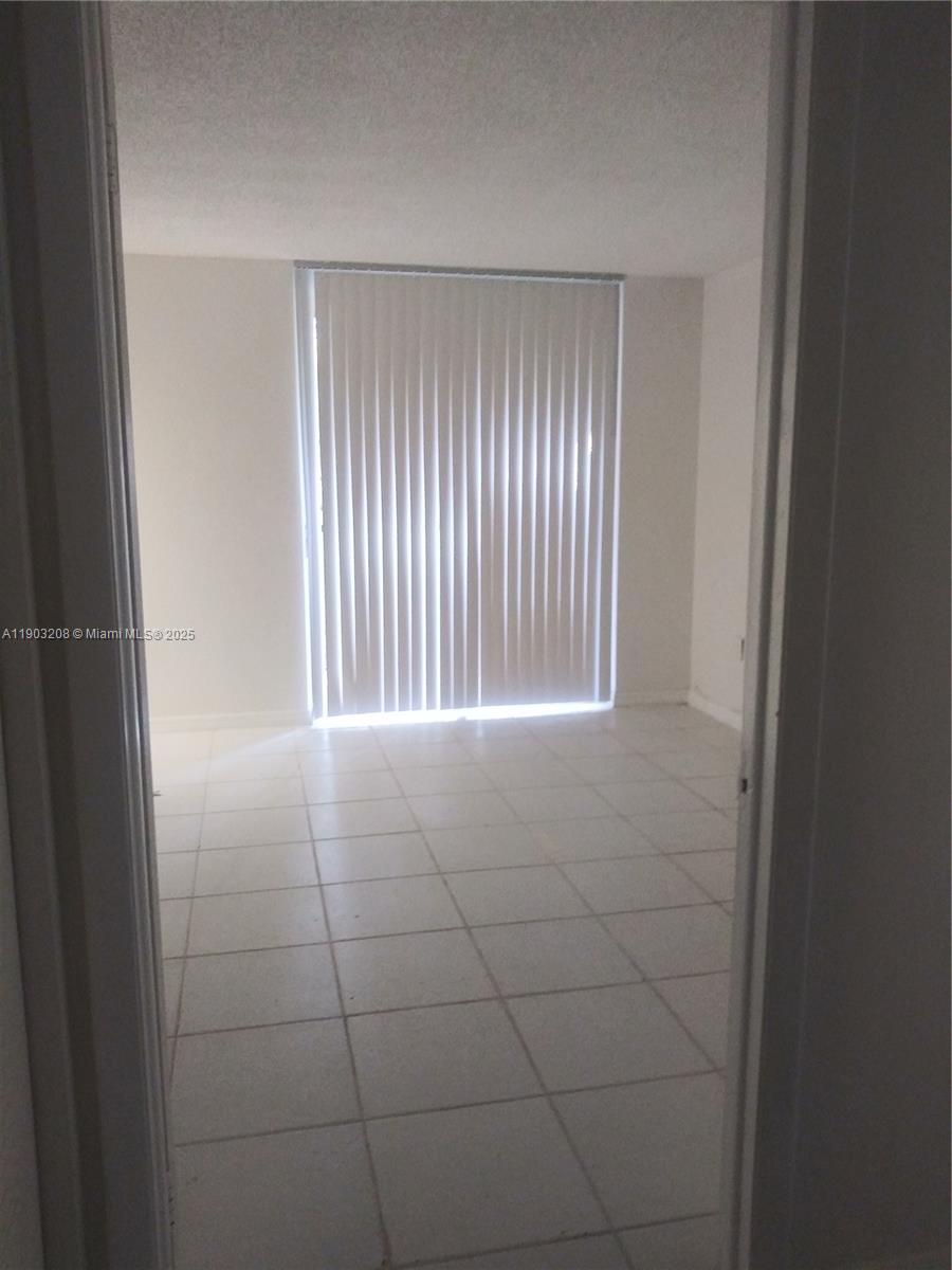 8650 Southwest 133rd Avenue Road, Unit 208 Miami, FL 33183 - Photo 9 of 10 a view of a livingroom with an empty space and a window