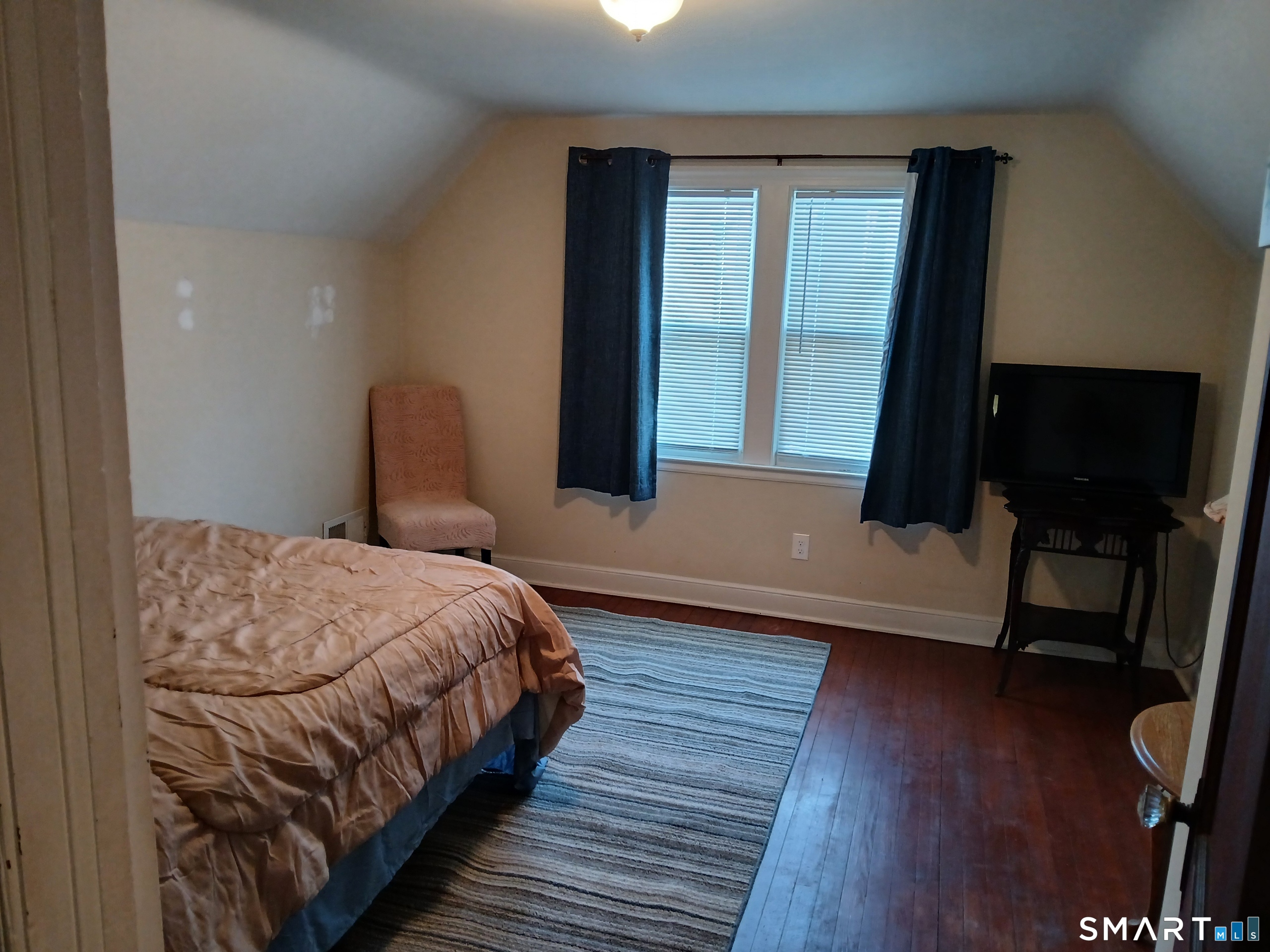194 Washington Avenue Torrington, CT 06790 - Photo 3 of 7 a bedroom with a bed a window and wooden floor