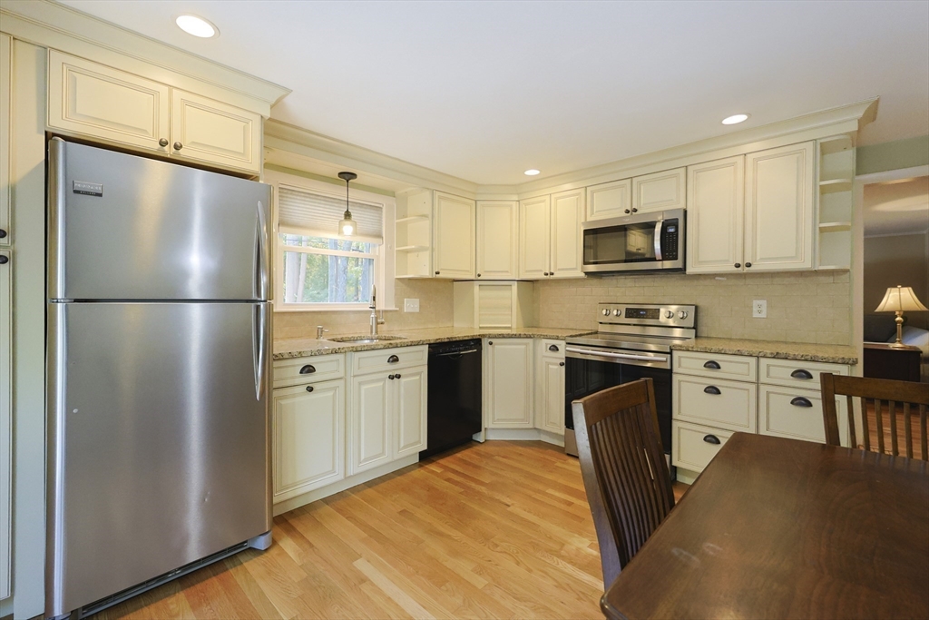 28 Forest Road Millis, MA 02054 - Photo 7 of 23 a kitchen with cabinets stainless steel appliances a sink and a refrigerator