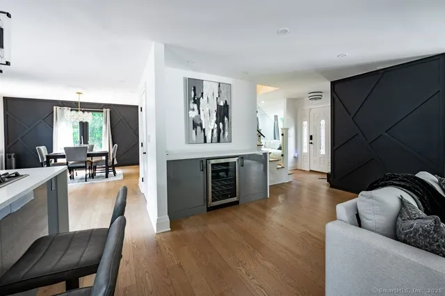 a view of kitchen island with stainless steel appliances wooden floor and living room view