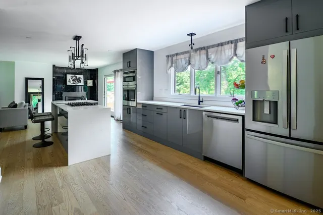 a view of a livingroom with a fireplace wooden floor and windows