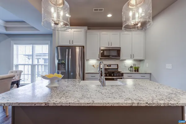 a kitchen with stainless steel appliances granite countertop a sink a stove and a granite counter top