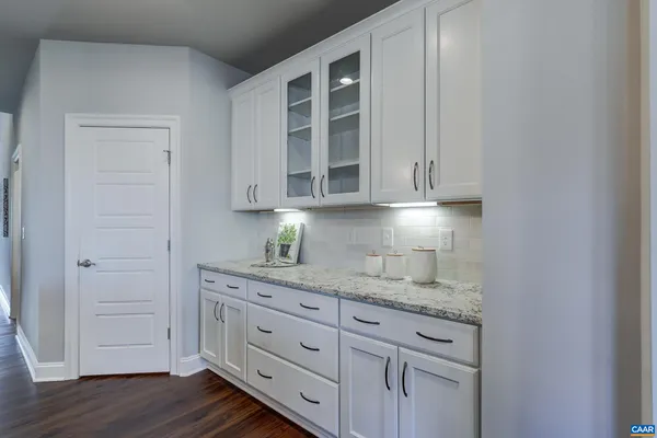 a kitchen with granite countertop white cabinets and sink