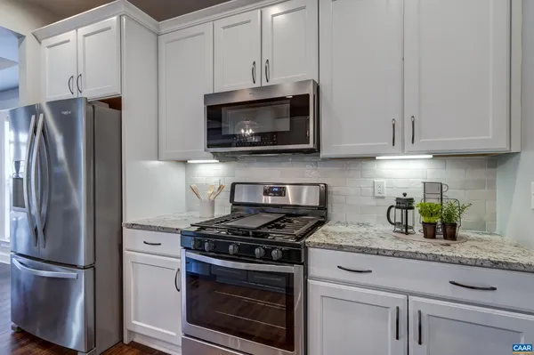 a kitchen with stainless steel appliances granite countertop a refrigerator stove and microwave