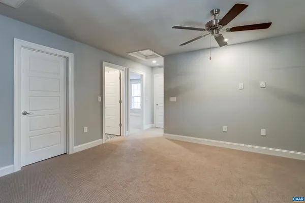 an empty room with windows and chandelier fan
