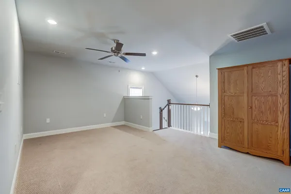 an empty room with windows and ceiling fan