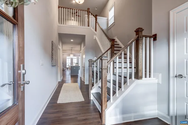 a view of staircase with lots of frames on wall and wooden floor