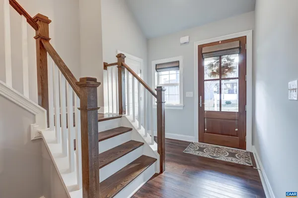 a view of an entryway with wooden floor and stairs