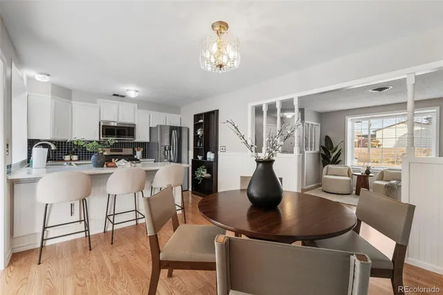 a dining room with furniture a chandelier and kitchen view