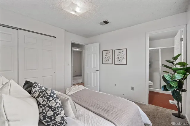 a bedroom with a bed and a potted plant