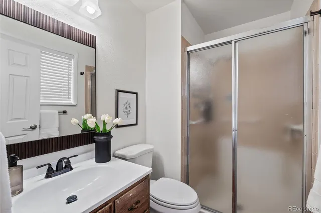 a bathroom with a sink vanity mirror and toilet