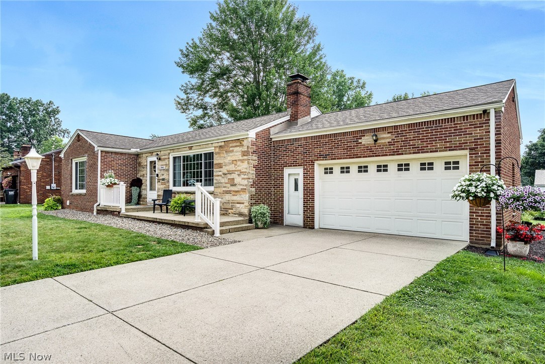 3940 Shelby Road Youngstown, OH 44511 - Photo 4 of 20 Brick exterior with stone accents, attached two-car garage, concrete driveway, front entry porch, and a shingled roof