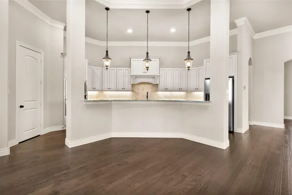 a kitchen with granite countertop a stove and white cabinets