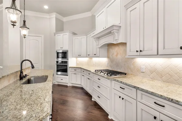 a kitchen with stainless steel appliances granite countertop a sink stove and refrigerator