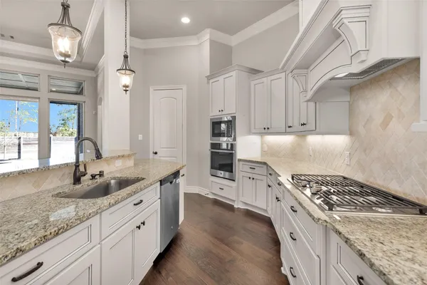 a kitchen with stainless steel appliances granite countertop a sink stove and refrigerator