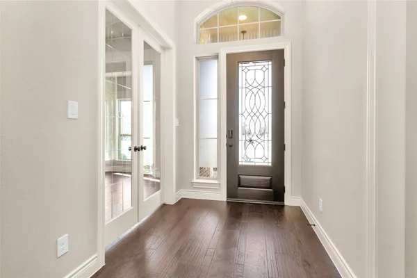 a view of a hallway with wooden floor and a livingroom