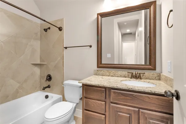 a bathroom with a granite countertop sink toilet a shower and a mirror