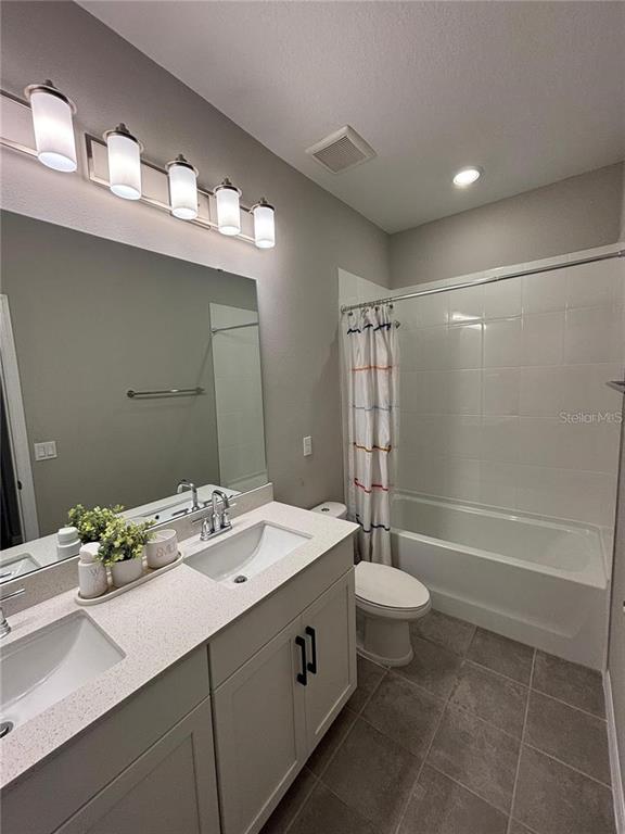 4812 Lime Rickey Alley Winter Garden, FL 34787 - Photo 18 of 19 a bathroom with a double vanity sink and a mirror