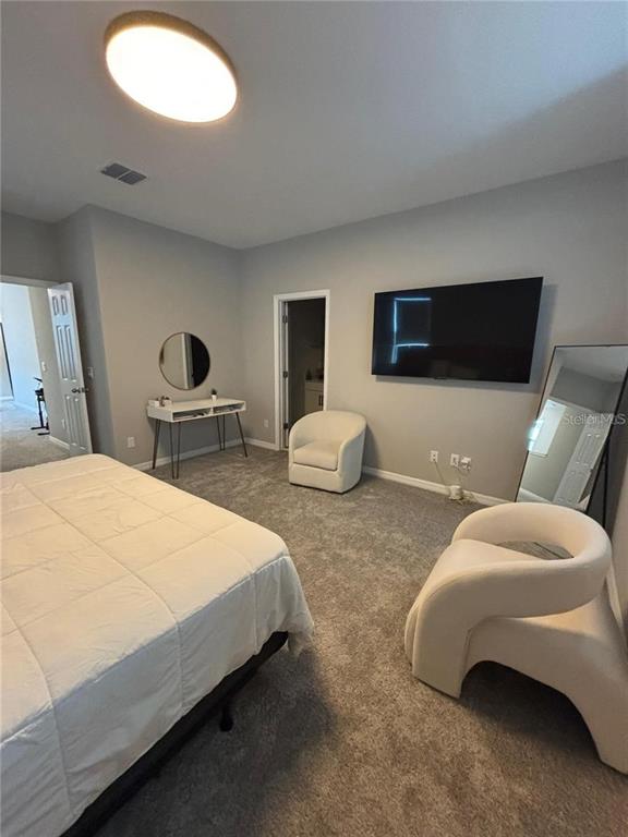 4812 Lime Rickey Alley Winter Garden, FL 34787 - Photo 9 of 19 a bedroom with furniture and a flat screen tv