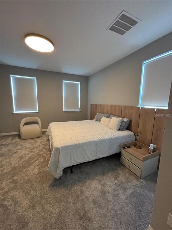 4812 Lime Rickey Alley Winter Garden, FL 34787 - Photo 10 of 19 a bedroom with bed and couch