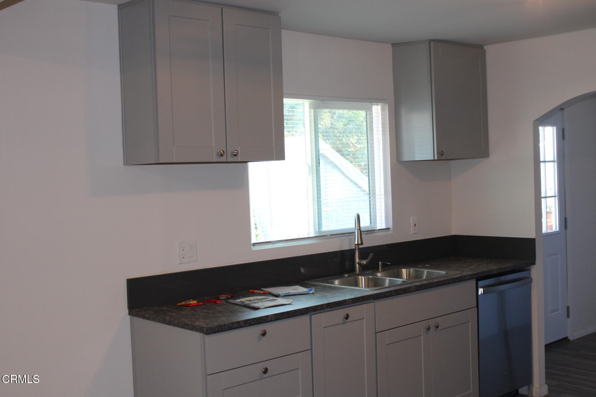 10031 Marcus Avenue Tujunga, CA 91042 - Photo 5 of 27 a kitchen with granite countertop white cabinets sink and window