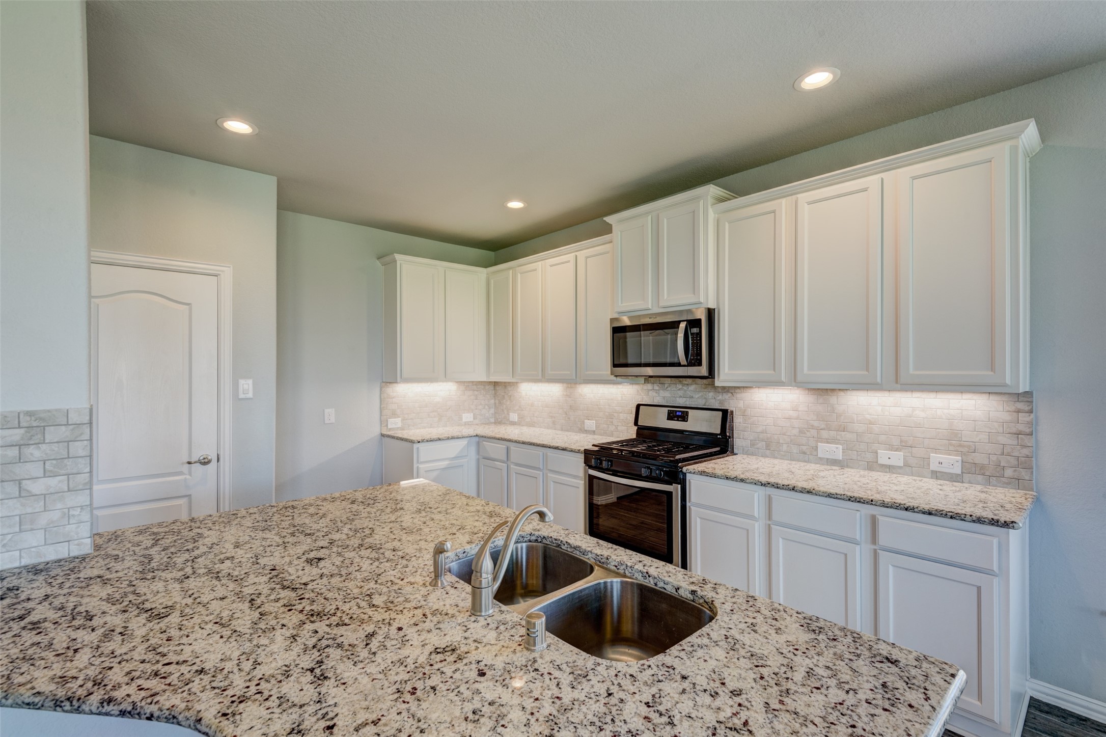 23421 Vineyard Drive Alvin, TX 77511 - Photo 11 of 32 a kitchen with a sink stove and refrigerator