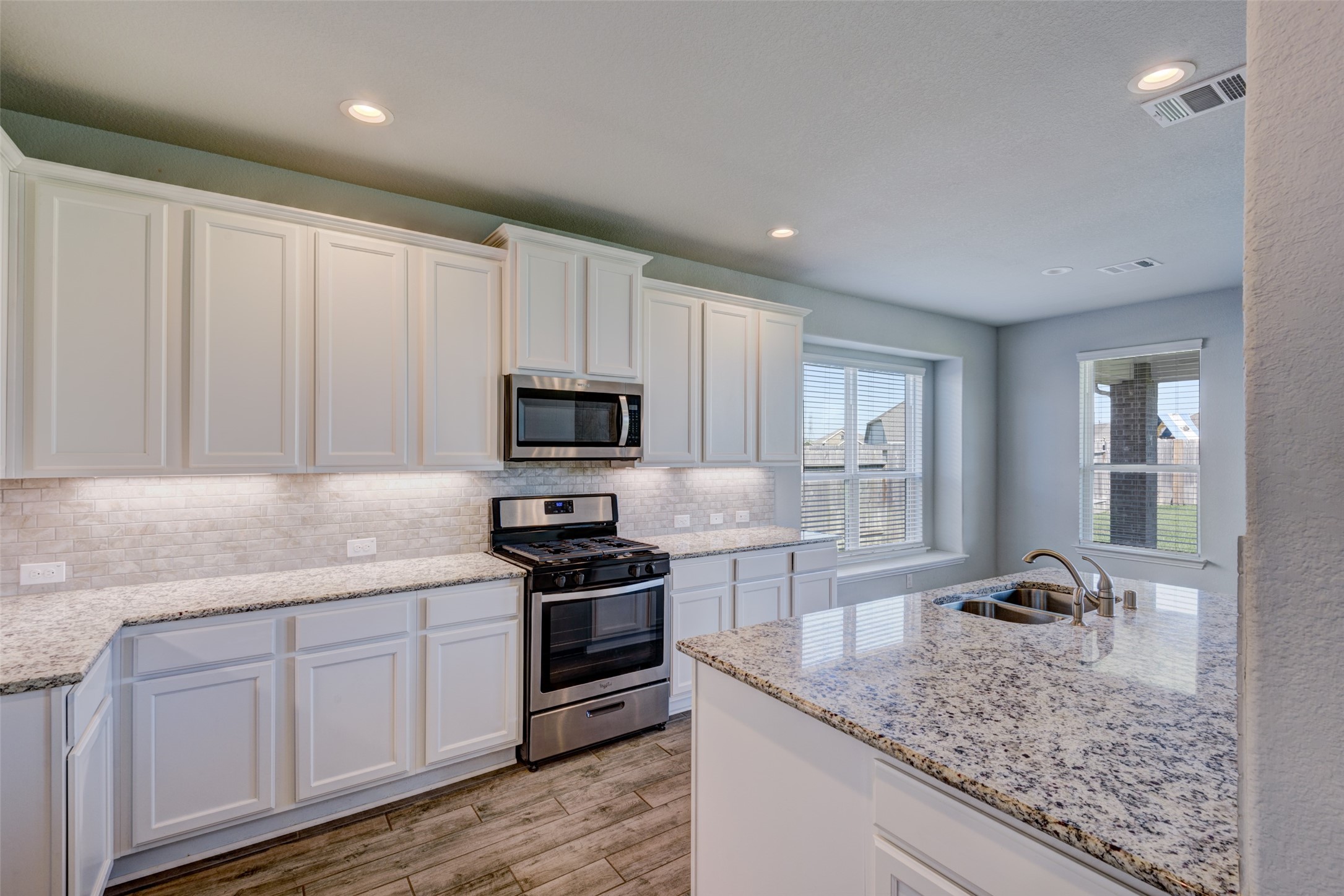 23421 Vineyard Drive Alvin, TX 77511 - Photo 14 of 32 a kitchen with stainless steel appliances granite countertop a sink stove and microwave